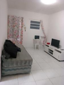 a living room with a bed and a tv at Ap01-A 50 Metros da Praia Flats Mobiliados para 4 Pessoas in Paulista