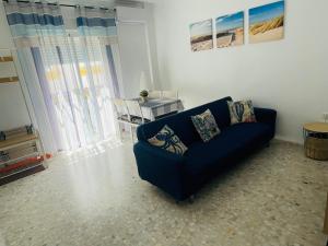 コニル・デ・ラ・フロンテーラにあるConil Playa & céntrico con Aire Acondicionado y WIFI -SOLO FAMILIAS Y PAREJAS-のリビングルーム(青いソファ、テーブル付)