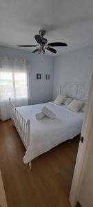a bedroom with a large white bed with a ceiling fan at Colibri Apartment Beach in Salou