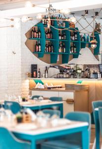a restaurant with blue tables and a green chandelier at La Onda Hotel Durres in Durrës