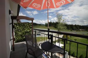 a balcony with a table and an umbrella at Motel Na Zbójeckiej in Skawa