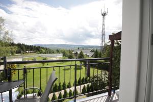 einen Balkon mit Blick auf ein grünes Feld in der Unterkunft Motel Na Zbójeckiej in Skawa