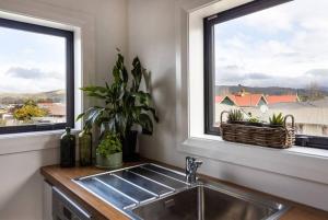 a kitchen with a sink and two windows at Apartment 2 - Haddin Court - Stunning Executive in Blenheim