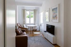 a living room with a couch and a table at Charming Flat at Monaco's Edge in Beausoleil
