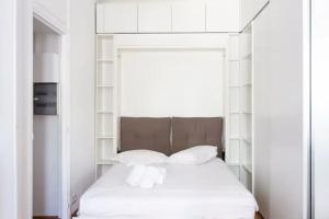 a bedroom with a white bed with white pillows at Charming Flat at Monaco's Edge in Beausoleil