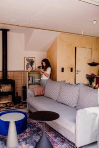 kobieta stojąca w salonie z kanapą w obiekcie Płyniewoda - całoroczne domy PREMIUM, klimatyzacja, kominek, blisko morza w Dziwnowie