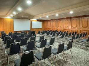 a conference room with chairs and a white screen at Hotel Melillanca in Valdivia