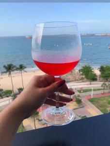 osoba trzymająca kieliszek wina z widokiem na plażę w obiekcie Avenida Beira Mar, The Best view! w mieście Fortaleza