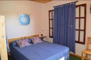 ein Schlafzimmer mit einem blauen Bett und einem Fenster in der Unterkunft Complejo Rancho Aparte in Villa Rumipal
