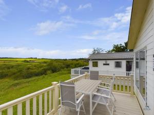 a deck with two chairs and a table on a house at 7 Medina Rise Family fun for all in Porchfield