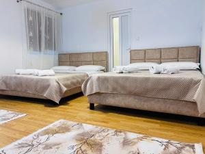 two beds in a room with wooden floors at IMPERIUM DK VILLA 
