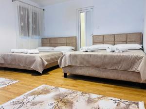 two beds in a room with wooden floors at IMPERIUM DK VILLA in Remuş +75 photos