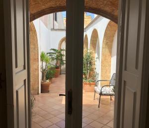 una puerta abierta a un patio con una silla en Lo Studio - Camilla's Guesthouse, en Morciano di Leuca