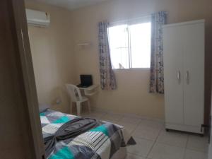 ein Schlafzimmer mit einem Bett, einem Fenster und einem Schreibtisch in der Unterkunft Ap 02-A 50 Metros da Praia Flats Mobiliados para 4 Pessoas in Paulista + 5 Fotos