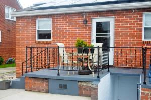 uma casa de tijolos com uma varanda com cadeiras em Home sweet home em Glen Burnie