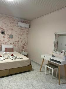 sypialnia z łóżkiem, biurkiem i lustrem w obiekcie Sunny house w mieście Kremasti