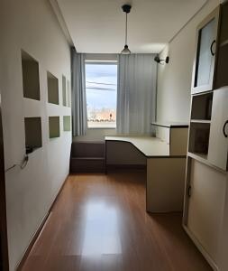 an empty room with a large window and a table at Casa segundo andar no Santa Efigênia in Belo Horizonte