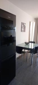 uma cozinha com um frigorífico preto e uma mesa em Villa Helena em Dramalj
