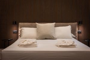 Una cama con almohadas blancas y toallas. en Luxury Suite Trevi, en Roma