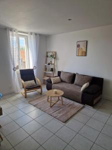 un soggiorno con un divano e un tavolo di ILEANA a Villefranche-de-Rouergue