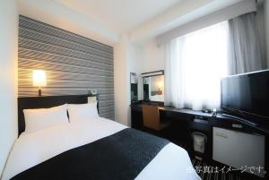 מיטה או מיטות בחדר ב-APA Hotel Saitama Shintoshin Eki-kita