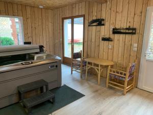 a kitchen with a stove and a table with chairs at Le Duo Porte-Joyeux in Porte-Joie