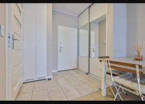 a room with a wooden table and a mirror at Airport Apartament Bokserska in Warsaw