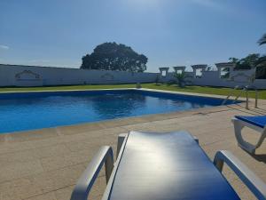 ein Pool mit einer Bank neben einem Gebäude in der Unterkunft Monte Santiago in Fronteira