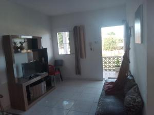 a living room with a couch and a television at Ap07-A 50 Metros da Praia Flats Mobiliados para 4 pessoas in Paulista
