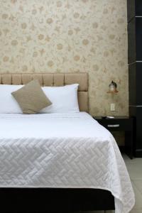 a bedroom with a bed with a white comforter at Hotel Presidente Internacional in Guayaquil