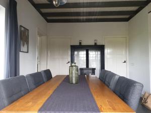 a large wooden table in a room with blue chairs at Erve Immink in Daarle