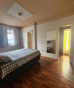 una grande camera da letto con un letto e un pavimento in legno di Casa no Santa Efigênia 5 quartos sendo 3 Suítes a Belo Horizonte Altre 37 foto