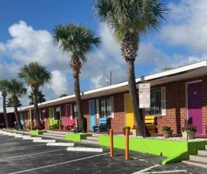 a row of palm trees in front of a building at Seahorse Inn in New Smyrna Beach