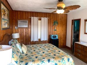 a bedroom with a bed and a ceiling fan at Seahorse Inn in New Smyrna Beach