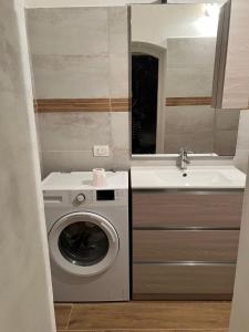 a bathroom with a washing machine and a sink at Mojito's house in Rio Marina