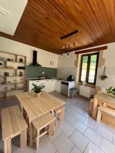 a large kitchen with a wooden table and benches at Maison Eclusière le Coup de Pompe in Meilhan-sur-Garonne