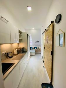 a kitchen with white cabinets and a long hallway at 36-Maniana - DeerRest Apart in Jelenia Góra
