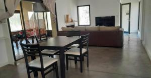 a living room with a table and chairs and a couch at Campo Timbo casa con pileta in Rosario