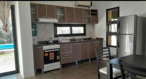 a kitchen with a stove and a refrigerator and a table at Campo Timbo casa con pileta in Rosario