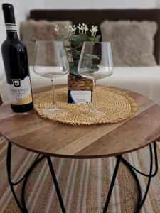 a table with a bottle of wine and two glasses at UKROPINA APARTMENTS in Trebinje