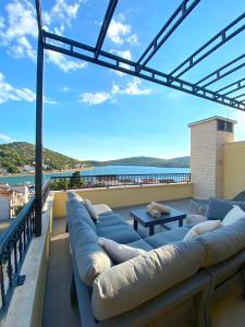 a couch on a balcony with a view of the water at House DMS in Tisno