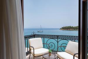 a balcony with two chairs and a view of the ocean at La Boheme Hotel in Gythio