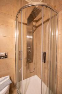 y baño con ducha y puerta de cristal. en La Boheme Hotel en Gytheio