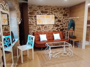 a living room with a couch and two chairs at Casa Desigual in Padrón