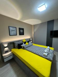 een slaapkamer met een geel bed in een kamer bij NOA Luxury Apartment in Bitola