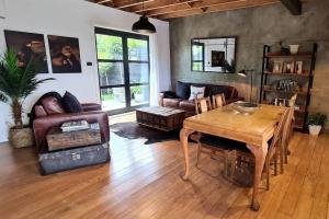 a living room with a table and a couch at Apartment 3 - Haddin Court - Industrial Glam in Blenheim +21 photos
