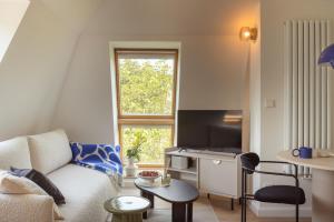 a living room with a couch and a tv at Sopot M17 - by JWPM in Sopot