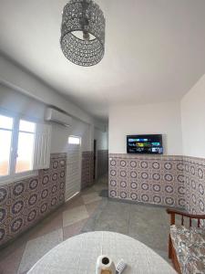a living room with a chandelier hanging from the ceiling at Al hoceima Center Apartment in Al Hoceïma