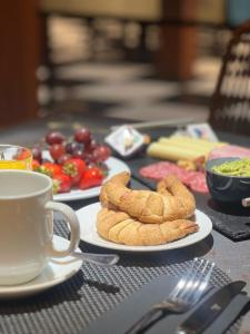a table with plates of food and a cup of coffee at Concha y Toro 33 Hotel Boutique by Nobile in Santiago