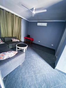 ein Wohnzimmer mit einem Sofa und einem Tisch in der Unterkunft Homeaway4m home in Daressalam